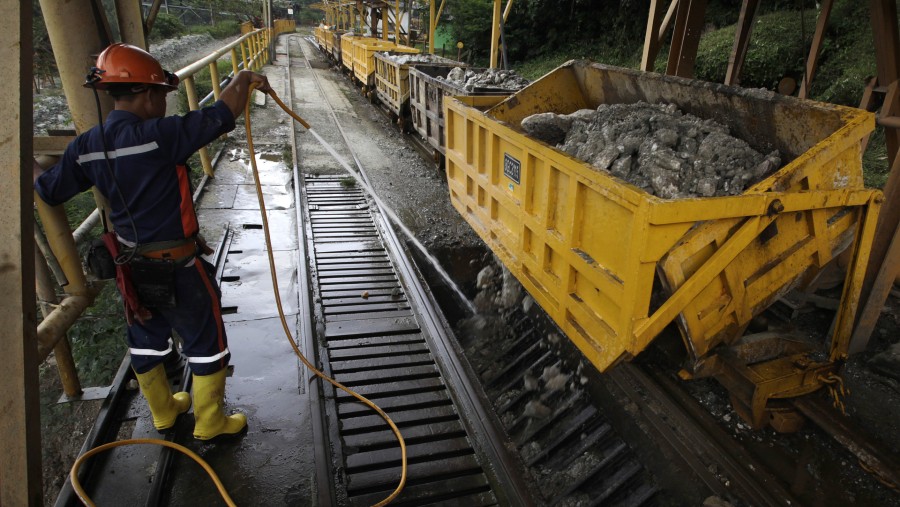 Pekerja menyemprotkan air saat bijih batu hasil tambang diturunkan di tambang emas PT Aneka Tambang (Antam) di Pongkor, Jabar/Bloomberg-Dadang Tri
