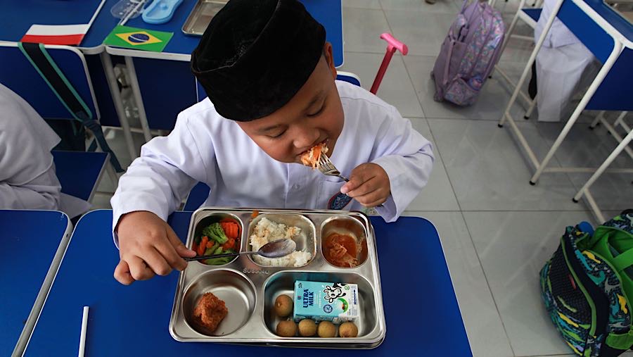 Siswa menyantap Makan Bergizi Gratis (MBG) di SD Angkasa 5 Halim, Jakarta Timur, Jumat (23/10/2025). (Bloomberg Technoz/Andrean Kristianto)