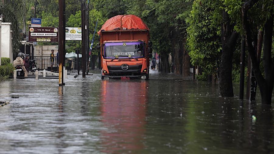 Pengendara melintasi banjir, Selasa (21/4/2026). (Bloomberg Technoz/Andrean Kristianto)