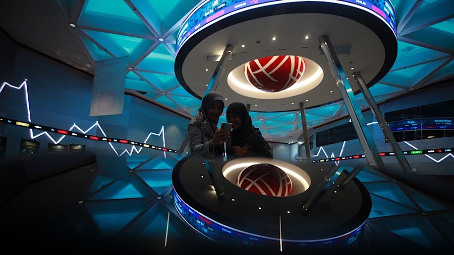 Pengunjung di depan layar pergerakan harga saham (IHSG) di Bursa Efek Indonesia (BEI), Kamis (29/1/2026). (Bloomberg Technoz/Andrean Kristianto)