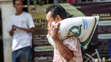Ilustrasi warga membawa bantuan sosial beras. Foto: Rifkianto Nugroho