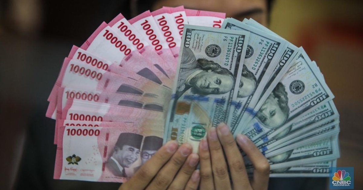 Foto: Petugas menjunjukkan uang pecahan dolar AS dan rupiah di Dolarindo Money Changer, Jakarta, Selasa (8/4/2025). (CNBC Indonesia/Faisal Rahman)